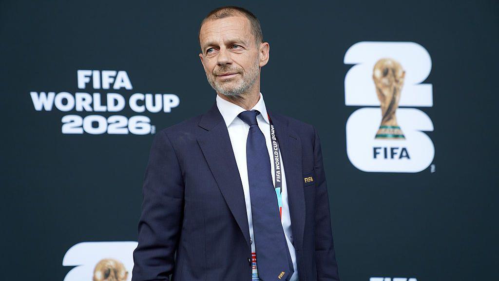 Uefa president Aleksander Ceferin in front of signage which reads Fifa World Cup 2026