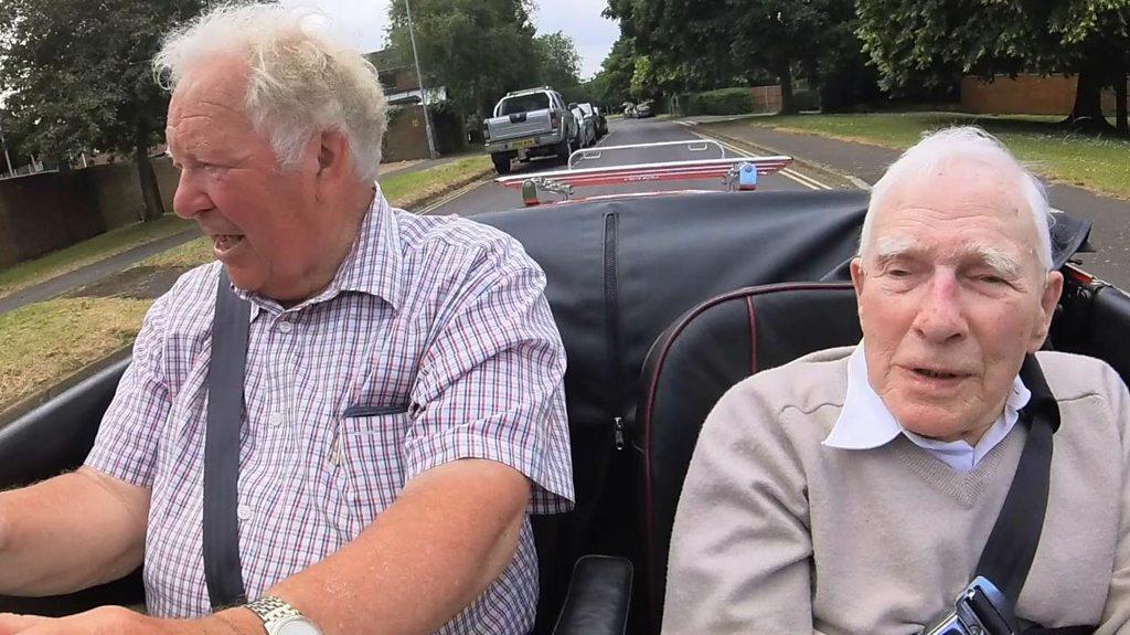 Roy driving in a classic car