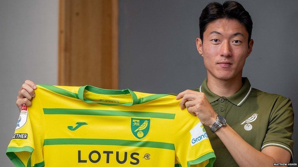 Hwang Ui-jo holding a Norwich City shirt