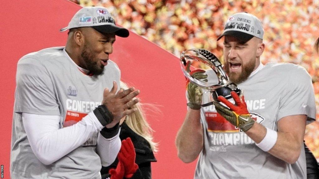 Travis Kelce with the AFC Championship trophy in 2023