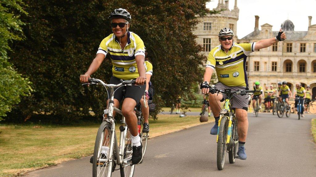 Cyclists smiling and waving