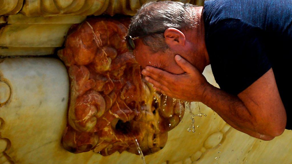 Man cooling himself in fountain