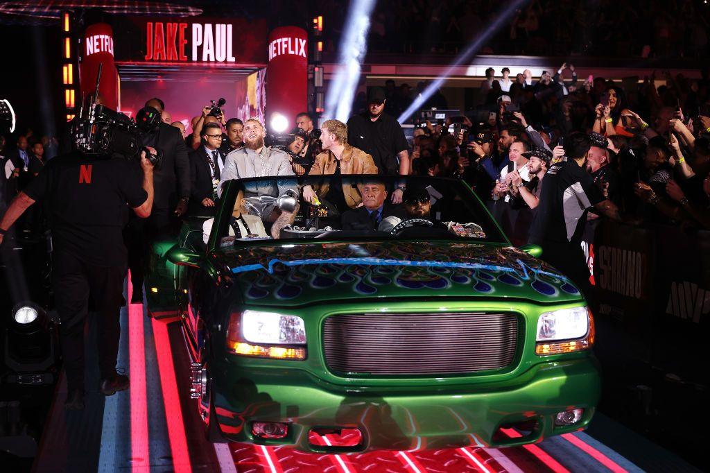 Jake Paul and Logan Paul enter the ring in a green truck