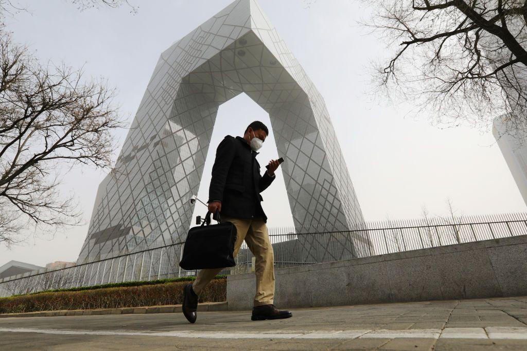 A man walks past the China Central Television (CCTV) headquarters building during a sandstorm on March 22, 2023 in Beijing,