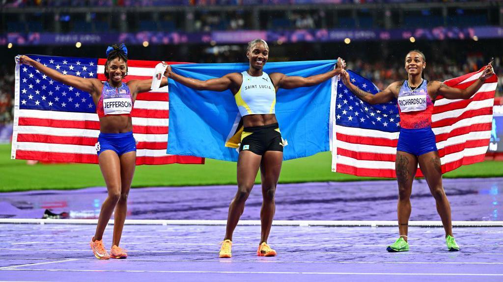 Sha'Carri Richardson, julien alfred and melissa jefferson holding their flags