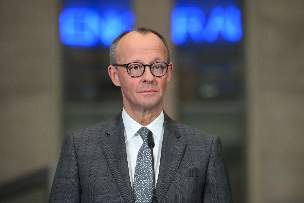 Germany's chancellor in waiting, Friedrich Merz, stands in a news conference in a grey suit