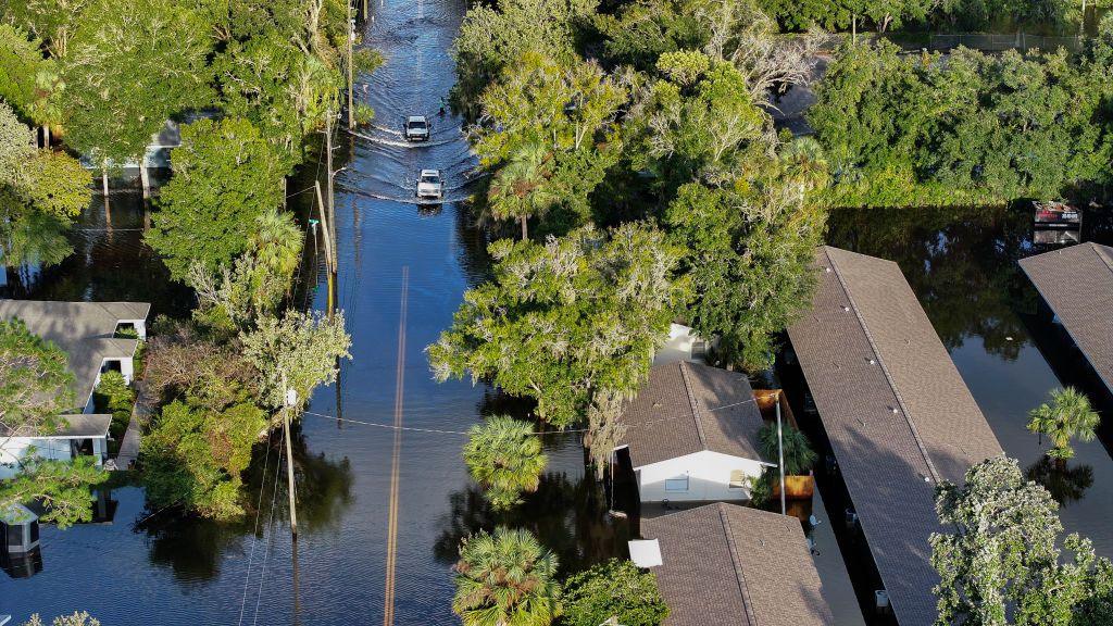 Vehicles drive through flood waters