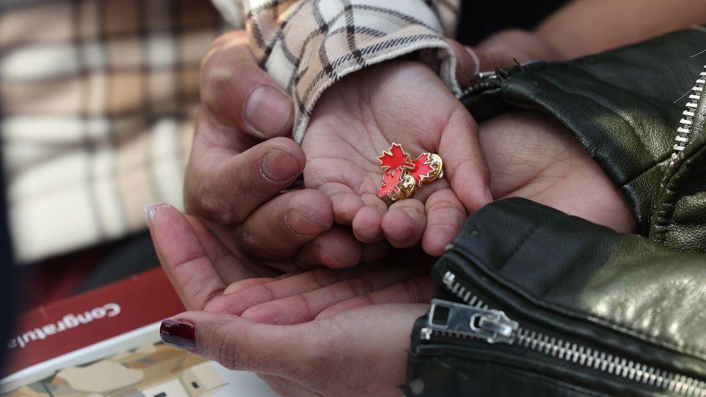 Six-year-old Canadian Gabriel Duclayna holds maple leaf pins as his parents Kenneth Duclayna and Regine Obsequo are sworn in as Canadian citizens in May 2024