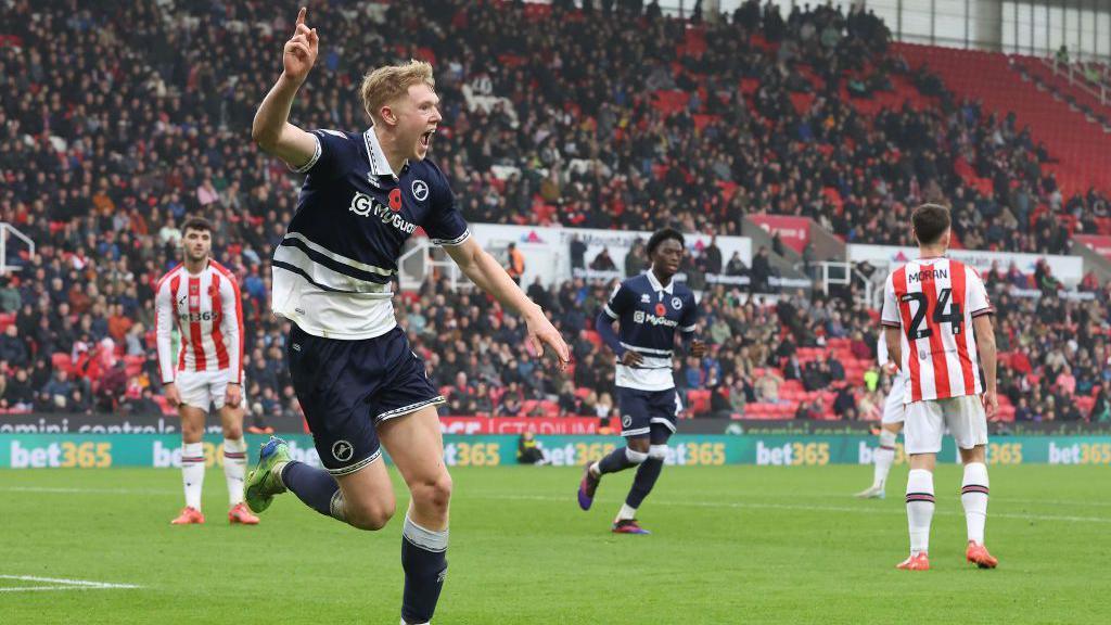 Josh Coburn runs and celebrates with his finger in the air after scoring against Stoke City