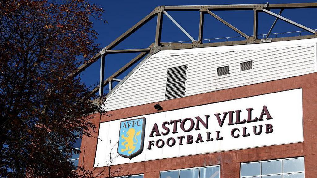 A sign reading 'Aston Villa Football Club' on the wall outside Villa Park