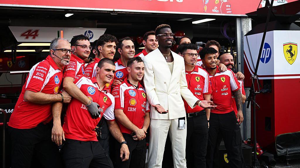 Paul Pogba takes a picture with the Ferrari team.