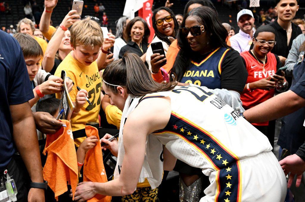 Caitlin Clark signs fan jerseys after the Indiana Fever defeat the Mystics in Washington on Friday.