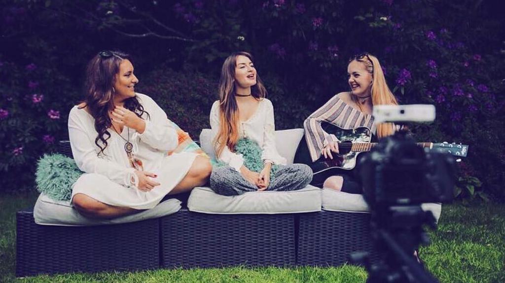 Remember Monday, sing together in the open air, while sitting on rattan garden furniture, in a photo from their early days as a band