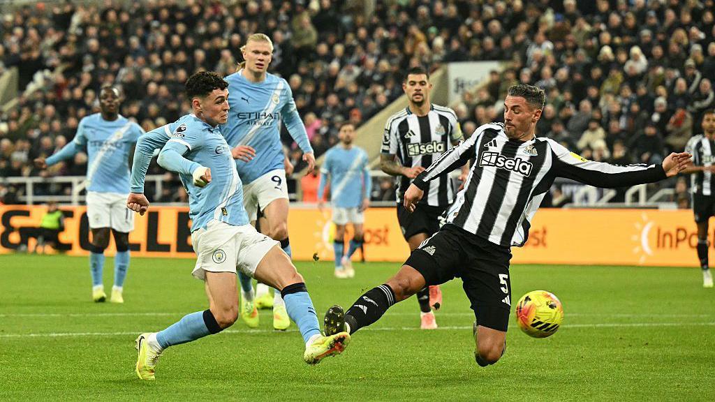 Fabian Schar connects with Manchester City's midfielder Phil Foden inside the area