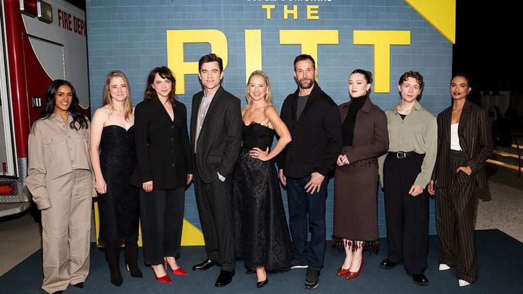 The cast of The Pitt on the red carpet smiling for photos.
