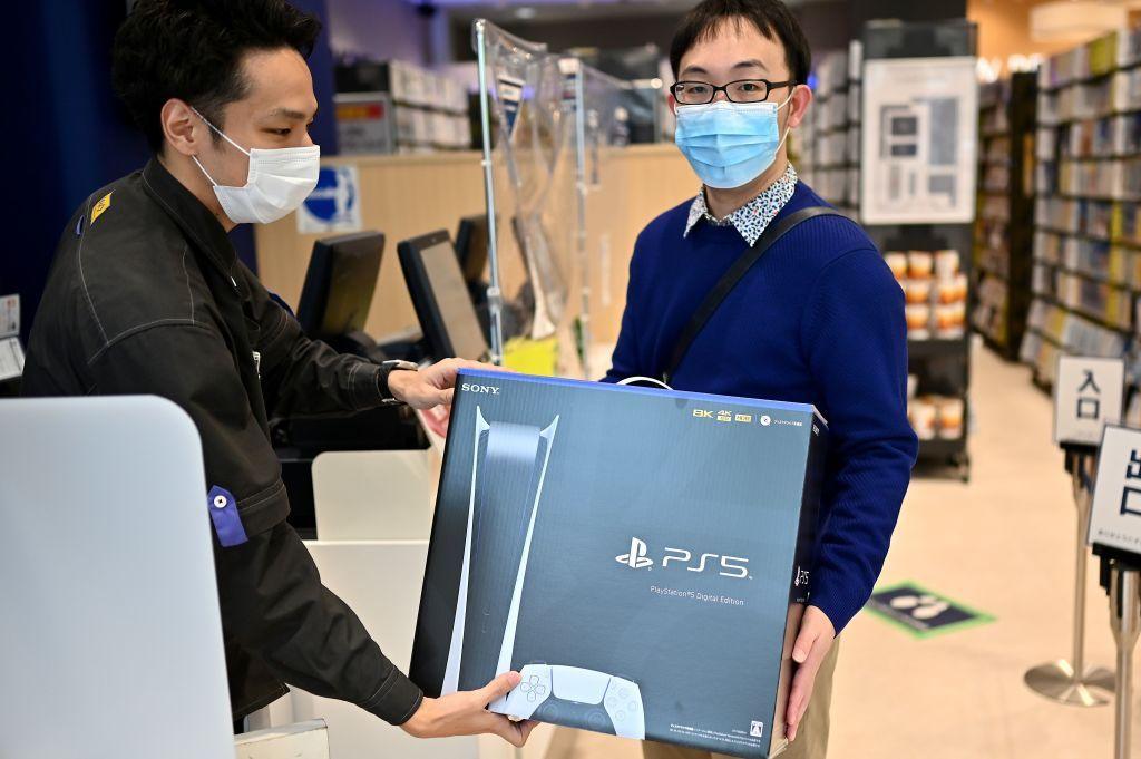 Two men holding the PlayStation 5.