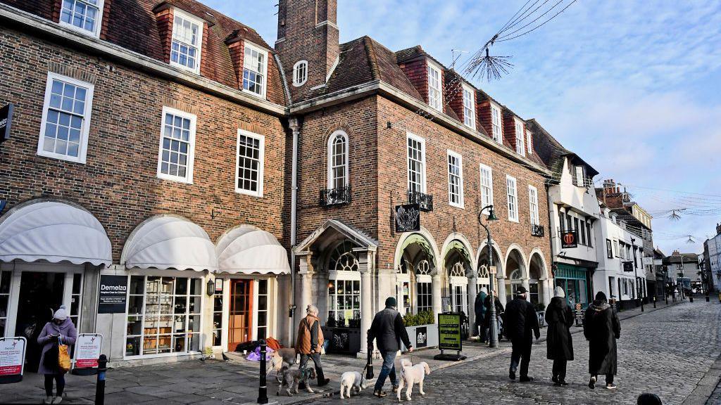 Visitors walking in a city centre.