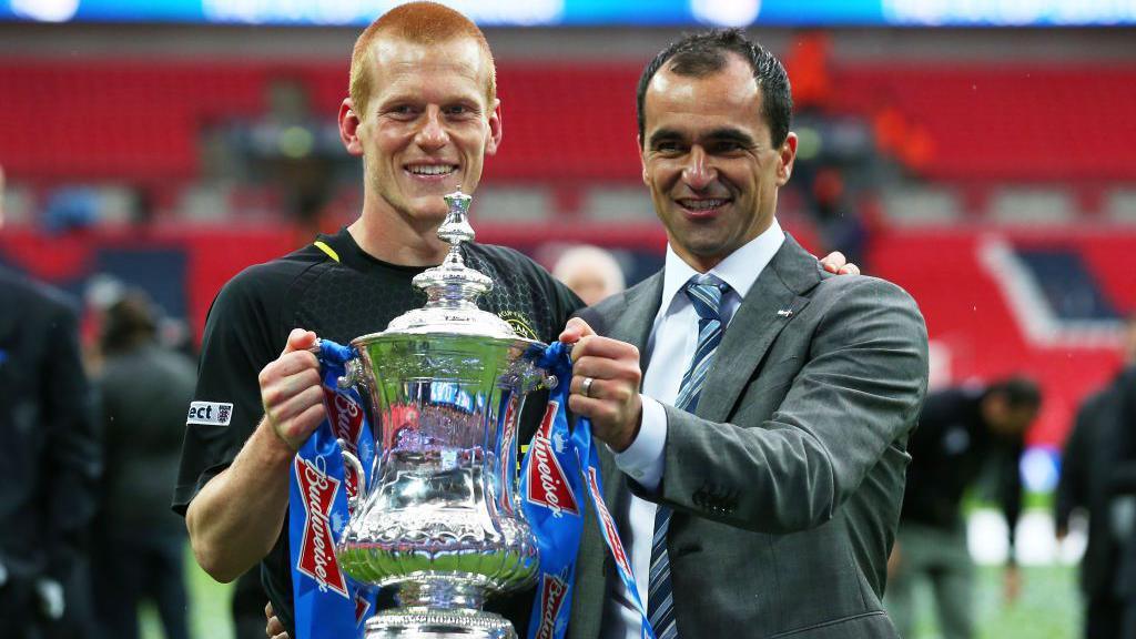 Roberto Martinez (right) holds the FA Cup trophy with matchwinner Ben Watson after Wigan beat Manchester City to win the competition in May 2013