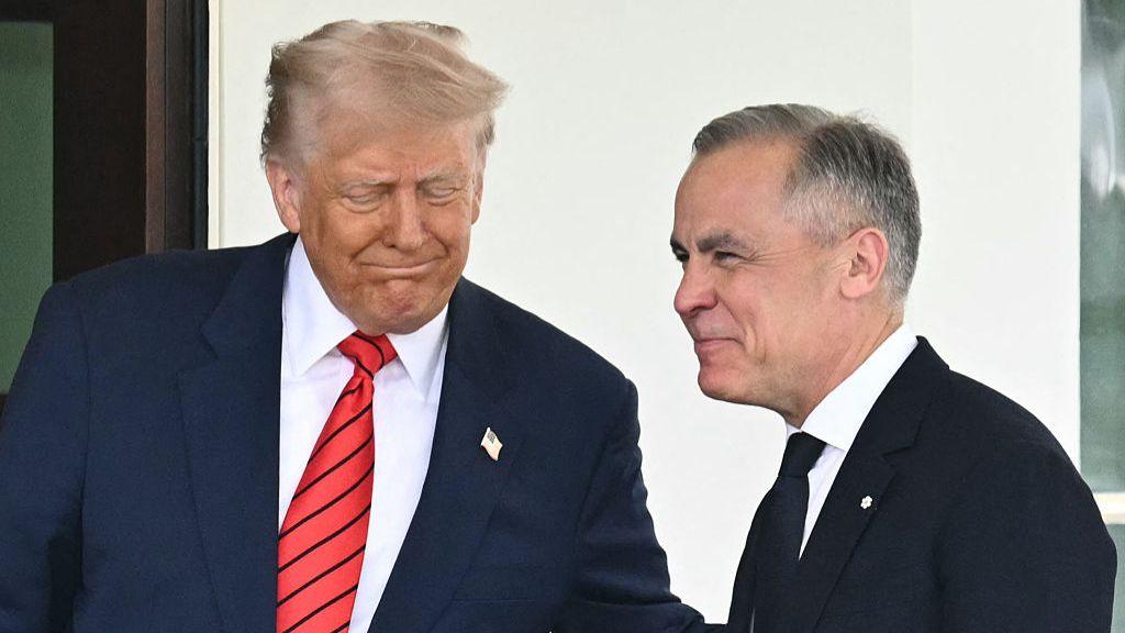 Donald Trump (L) grimaces as he shakes hands with Mark Carney (R) outside the White House
