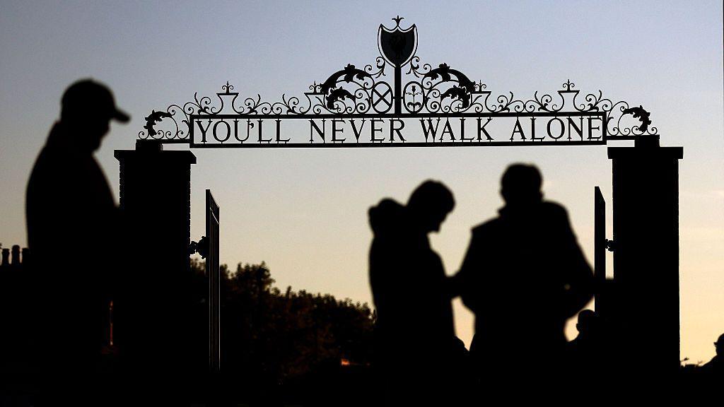 A silhouetted view of the Shankly Gates outside Anfield which read 'You'll Never Walk Alone'