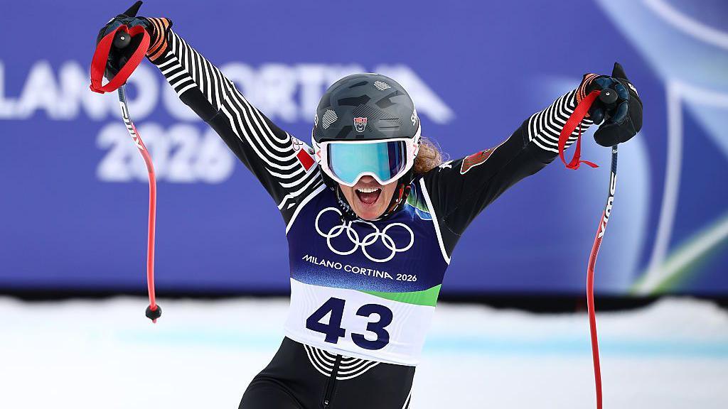 Sarah Schleper poses with her trademark v dive as she zooms down the slopes at the Winter Olympics.