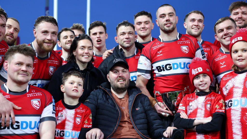 Former Gloucester and Leicester player, Ed Slater poses with members of his family and players from the winning team, Gloucester during the Slater Trophy presentation