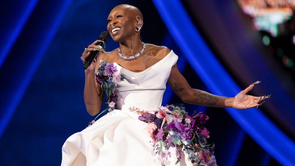 Cynthia Erivo holding a microphone.