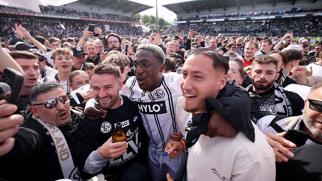 Elversberg players and supporters celebrate on the pitch