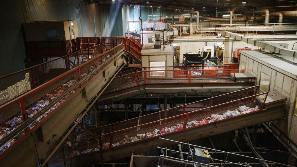 Mixed material waste for recycling moves along conveyors at the Veolia Southwark Integrated Waste Management Facility in London. There is a range of different coloured materials on the conveyor belts