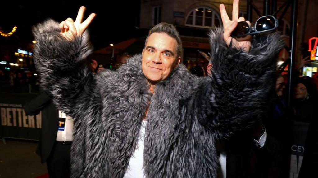 Robbie Williams giving victory signs