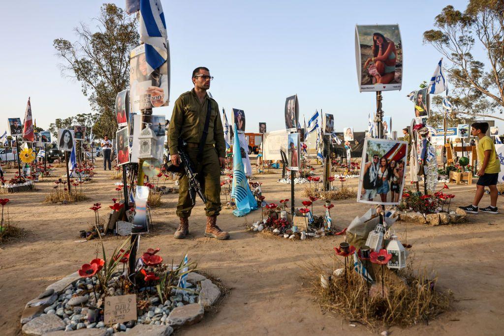 a soldier stands in a memorial to those killed on 7 October 2023