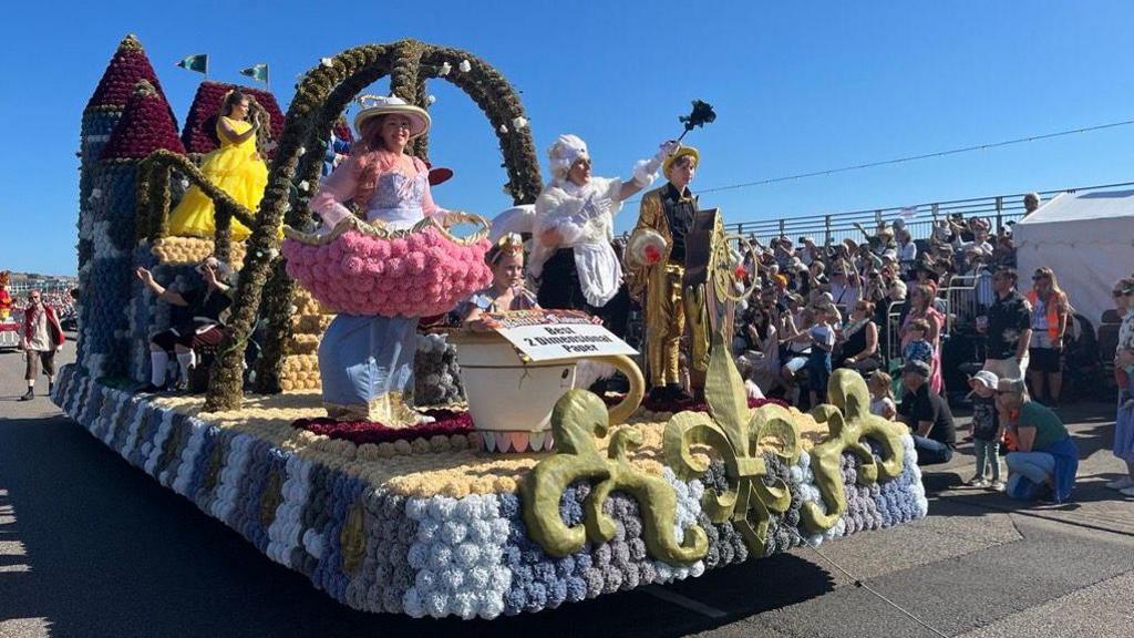 A paper flower float themed around Beauty and the Beast