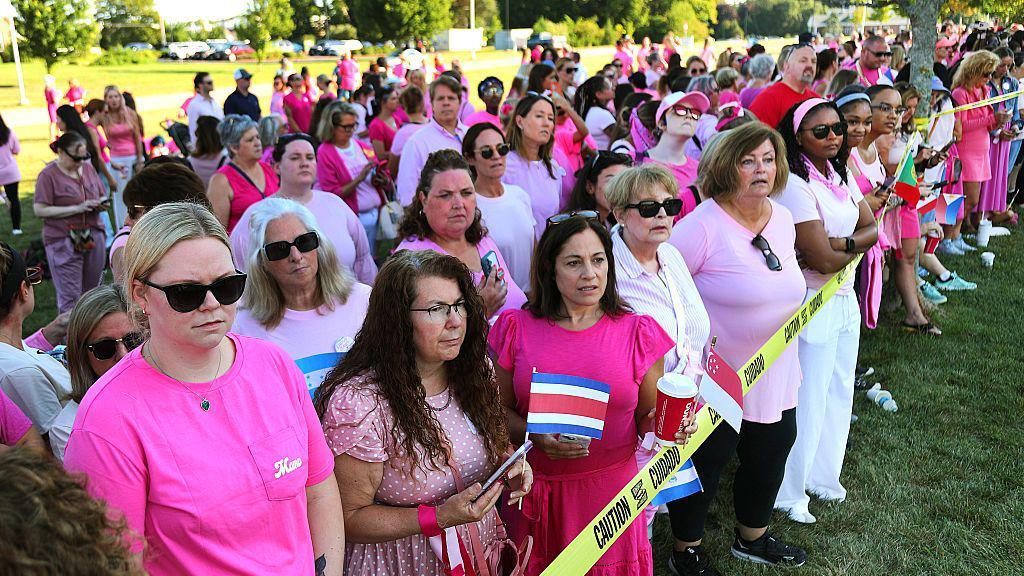 Women in pink shirts gather outside of Clancy's trial to support her