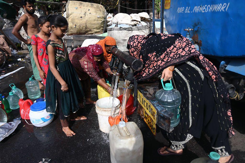 People gathering around a water tanker