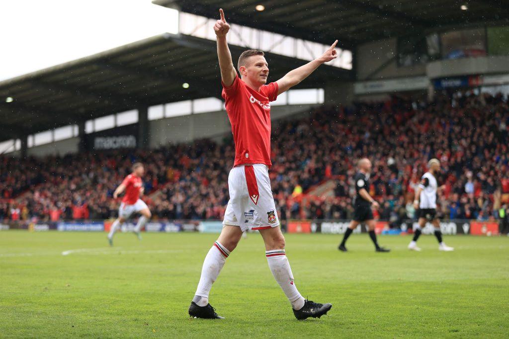 Paul Mullin holds aloft both hands in celebration while playing for Wrexham 
