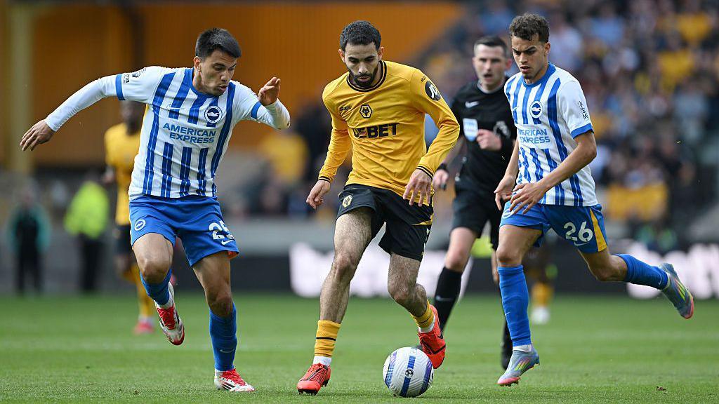 Rayan Ait-Nouri dribbles his way past two Brighton defenders