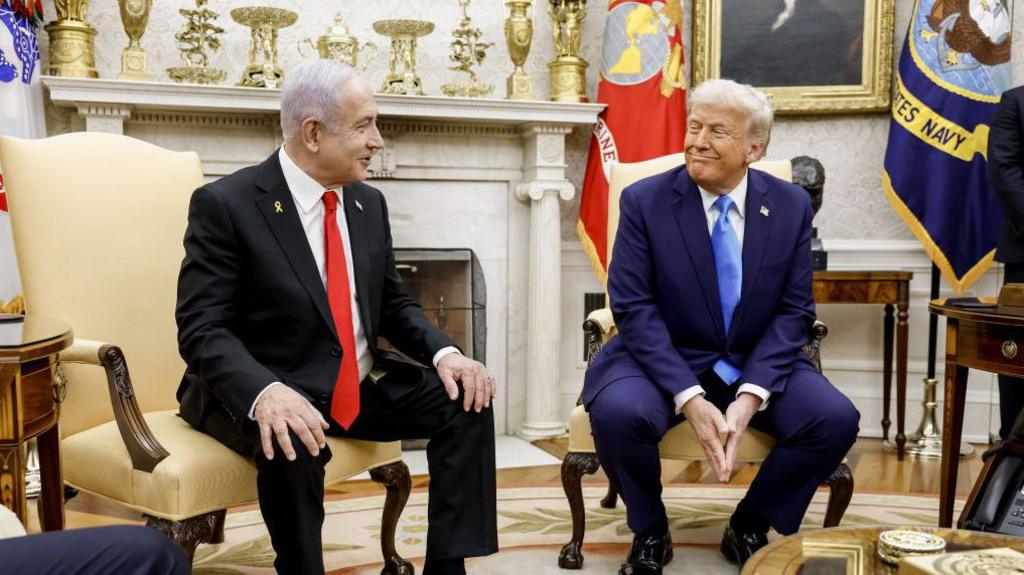 Trump and Netanyahu seated in the Oval Office, smiling at one another 