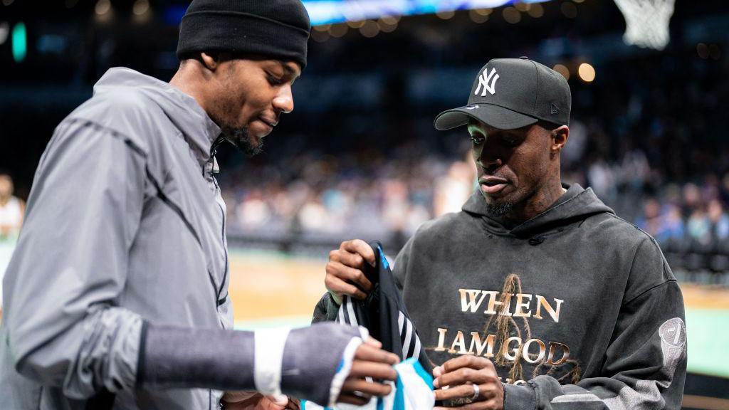 Brandon Miller of the Charlotte Hornets exchanges jerseys with Wilfried Zaha of Charlotte FC during their game against the Denver Nuggets at Spectrum Center