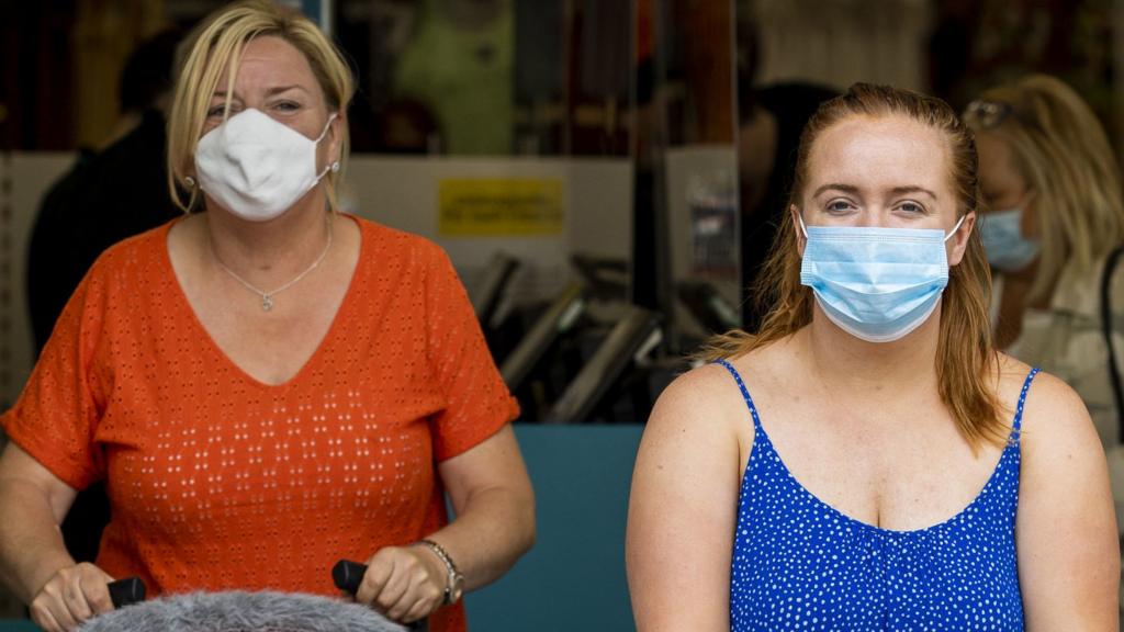 Two women wearing masks