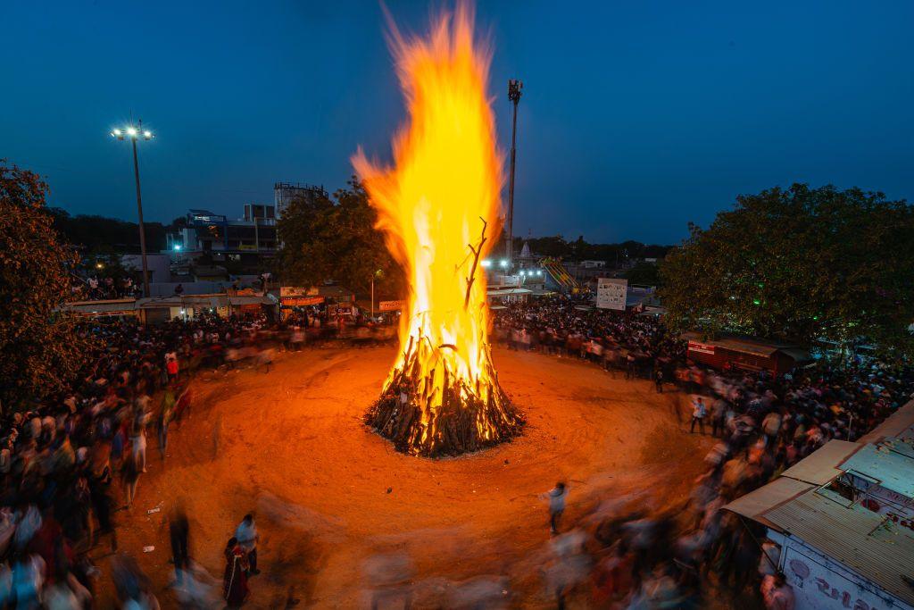 A bonfire lit on the occasion of Holi festival, with people surrounding it in a circle