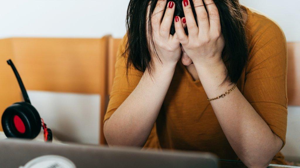 A stock image of a woman head in hands