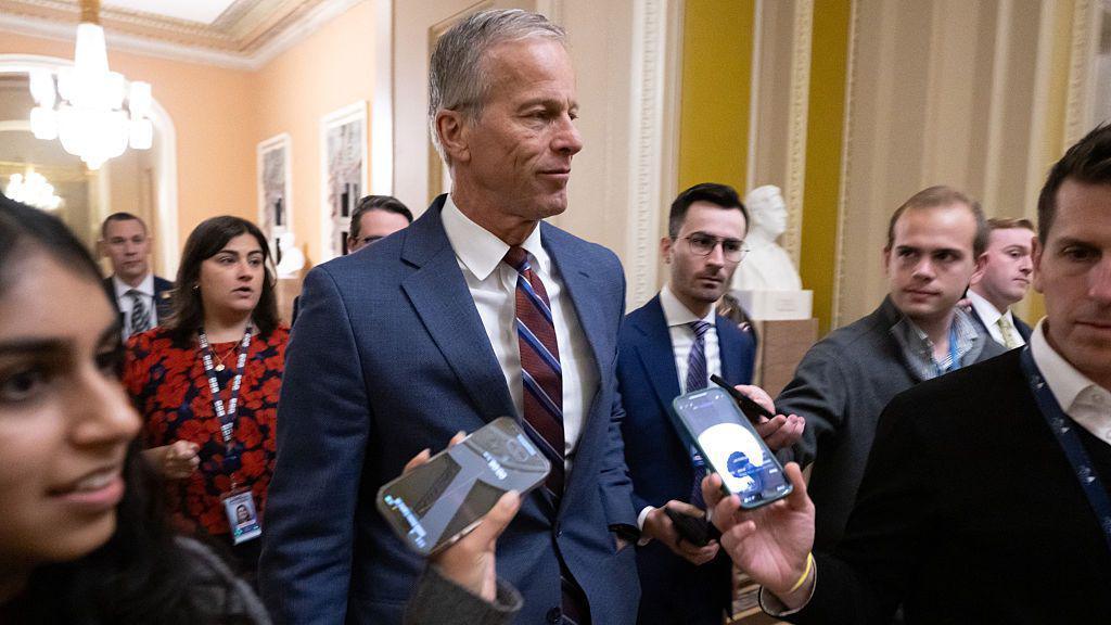 Senator Thune surrounded by journalists holding out phones to record him