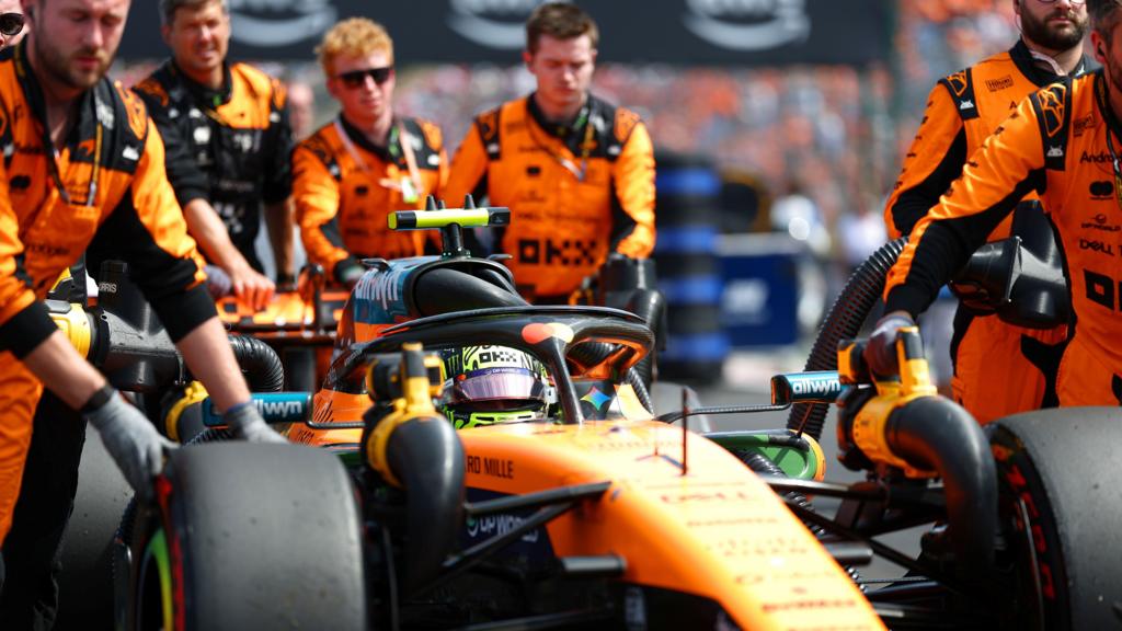 The McLaren of Lando Norris is pushed into position by his mechanics on the grid before the start of the Hugarian Grand Prix