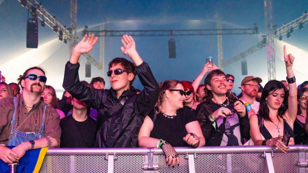 Festival-goers dance, cheer and take photos from the front row during a performance at All Points East in Victoria Park.
