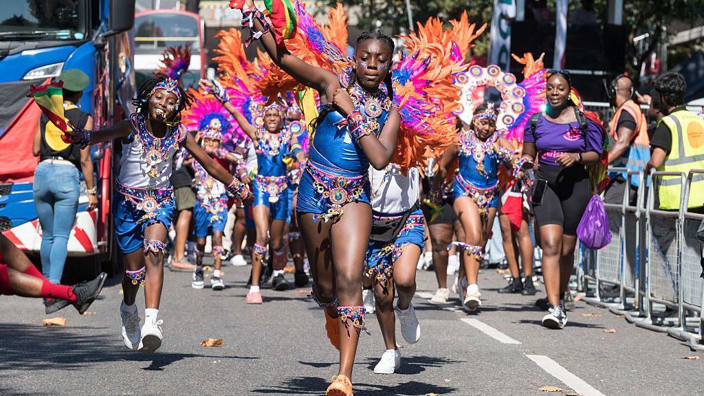 Children dancing in colourful costumes.