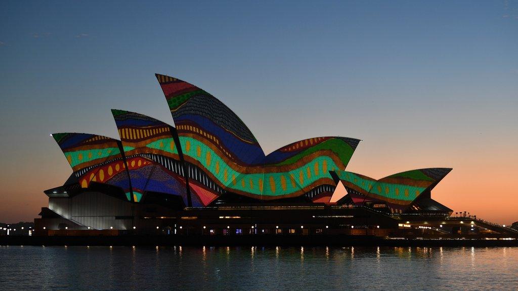 The sails of the Sydney Opera House are lit up at dawn with an artwork by Indigenous artist Frances Belle-Parker