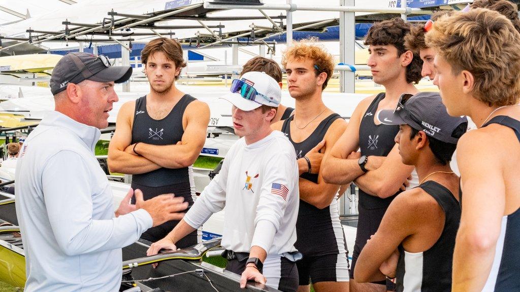 A rowing team gathered around coach