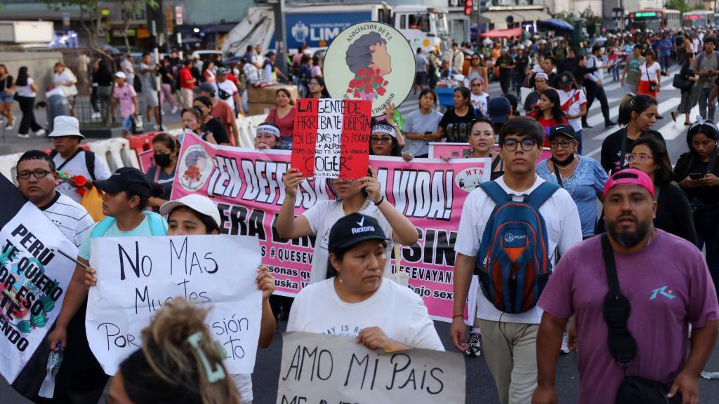 Demonstrators hold signs against violence during a national march against organized crime and hired assassinations, called by social and political organizations in Lima on March 21, 2025.