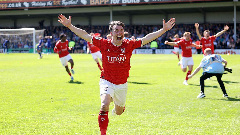 Ryan Fallowfield of York City celebrates after teammate Josh Stones (not pictured) scored to equalise and secure the team's promotion during the Enterprise National League match between Rochdale and York City at Crown Oil Arena.