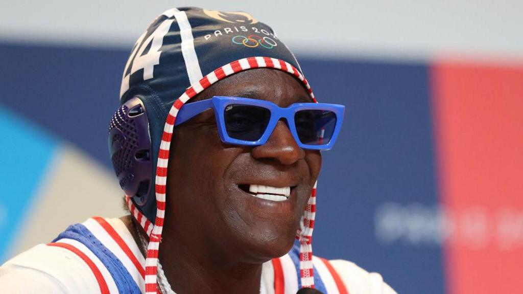Rapper Flavor Flav wearing an Olympic hat